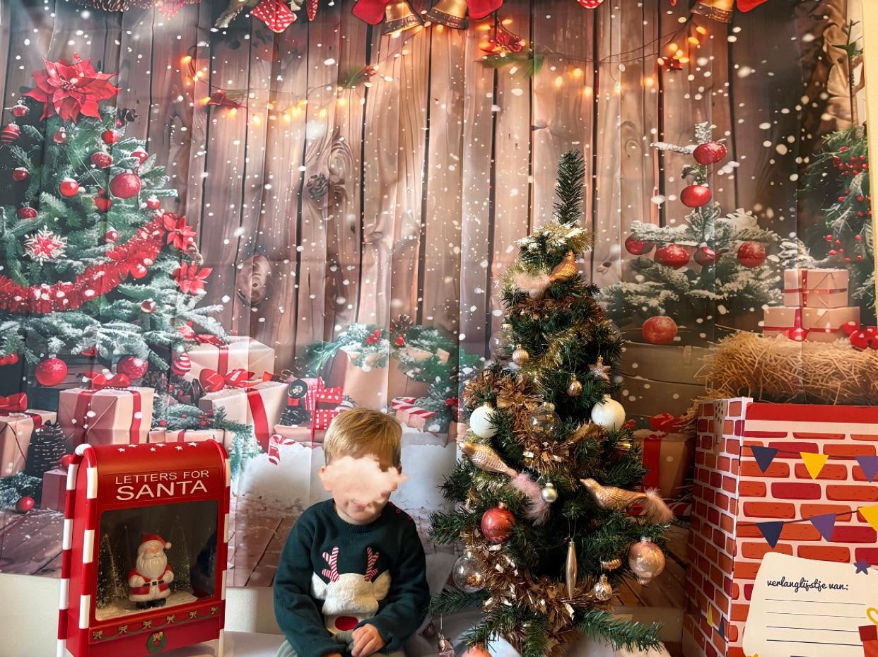 Séance photo de Noël devant le sapin et la cheminée décorée