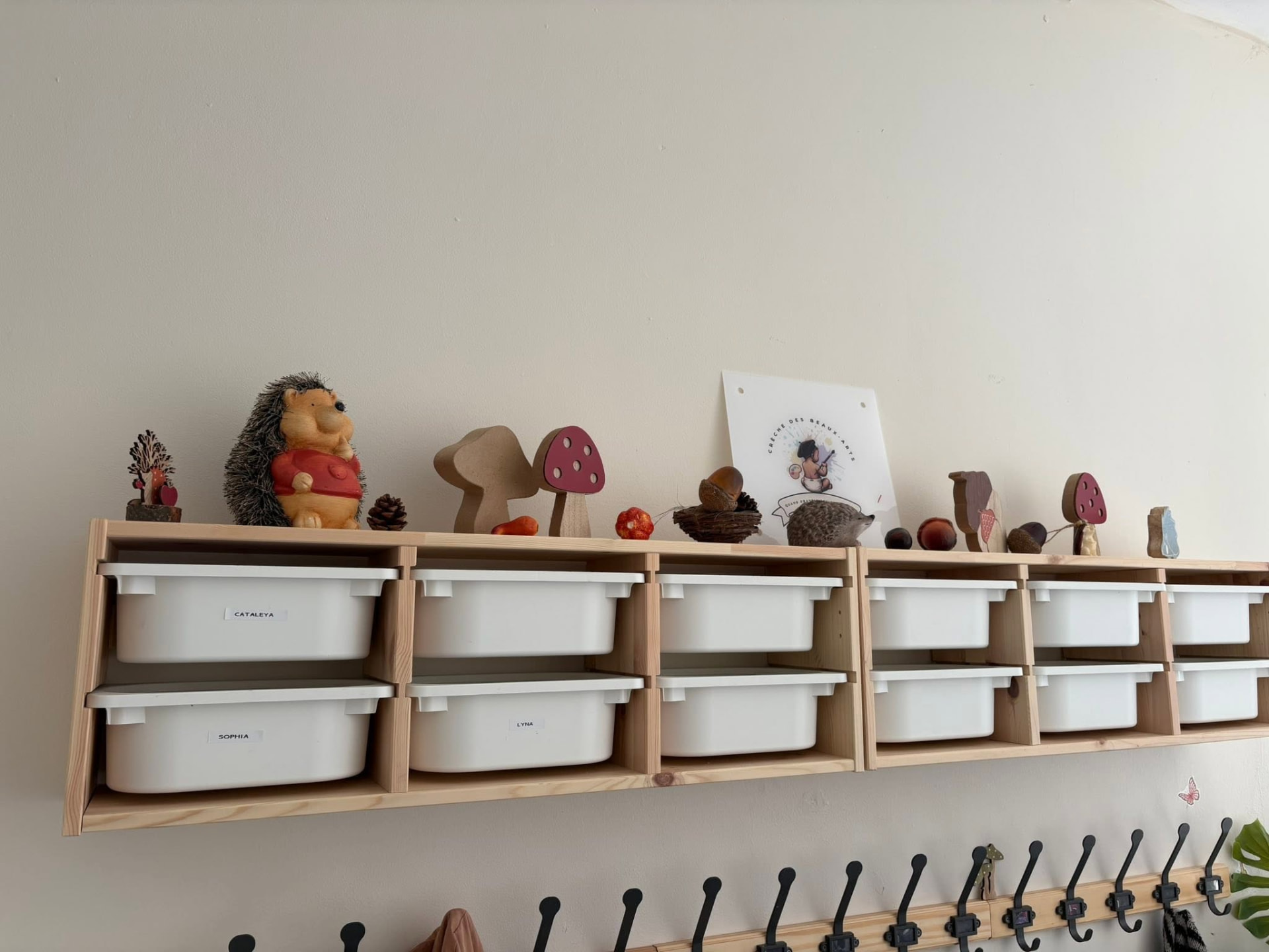 Vestiaire de la crèche, ses casiers en bois et ses bacs de rangement